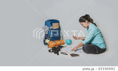 Tourist planning vacation with the help of world map with other travel accessories around Tourist planning vacation with the help of world map with other travel accessories around 65590991