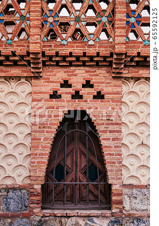 Red brick ornate vintage wall of Pavilion Guell in Barcelona Red brick ornate vintage wall of Pavilion Guell in Barcelona 65592125