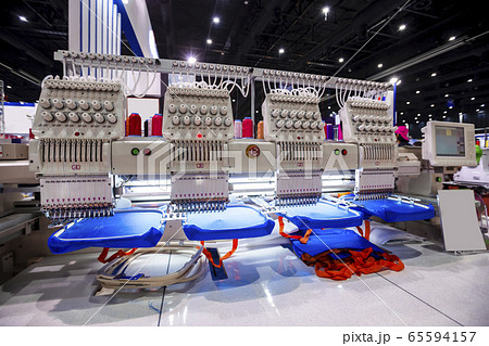 Textile - Professional and industrial embroidery machine. Machine embroidery is an embroidery process whereby a sewing machine or embroidery machine is used to create patterns on textiles. 65594157