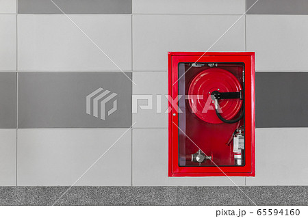 Hydrant with water hoses and fire extinguish equipment on the wall in an corridor. Hydrant with water hoses and fire extinguish equipment on the wall in an corridor. 65594160