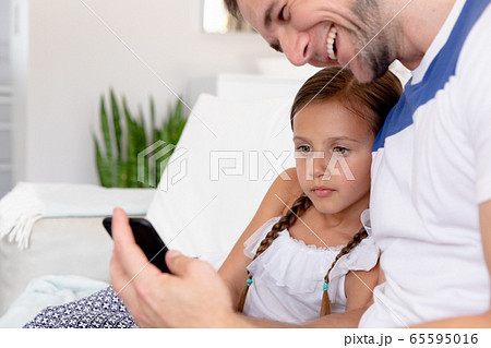 Caucasian girl and her dad spending time together at home 65595016