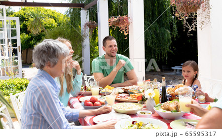 Caucasian family sitting at table during a family lunch in the garden 65595317