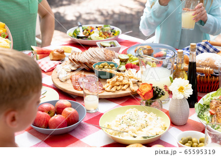 Caucasian family sitting at table during a family lunch in the garden Caucasian family sitting at table during a family lunch in the garden 65595319