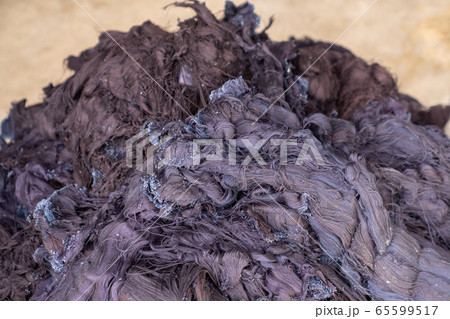 Fabric scraps, old clothing and textiles are cut into strips waiting for recycle. 65599517