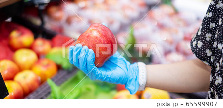 woman wearing nitrile gloves and holding Red apple 65599907