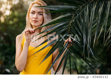 Woman in swimsuit on tropical plants background 65600132