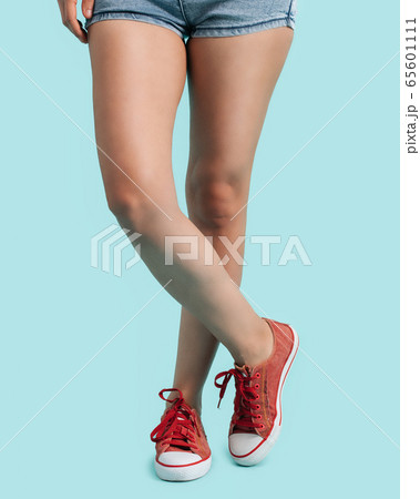 Woman wearing a red sneakers. On blue background Woman wearing a red sneakers. On blue background 65601111
