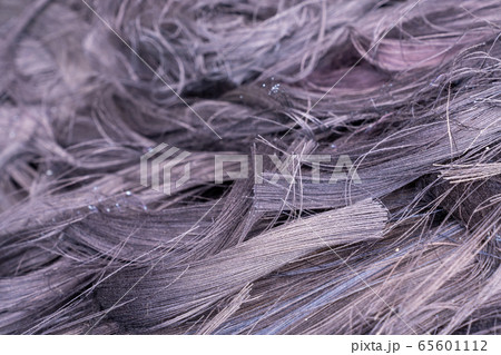 Fabric scraps, old clothing and textiles are cut into strips waiting for recycle. 65601112