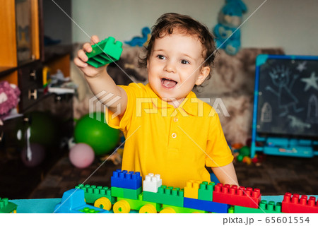 Child boy playing with cubes at home 65601554