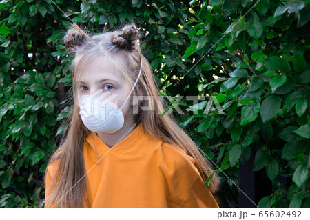 Teenager girl in a medical protective mask. Keep a social distance. To avoid coronavirus covid-19 transmission Teenager girl in a medical protective mask. Keep a social distance. To avoid coronavirus covid-19 transmission 65602492