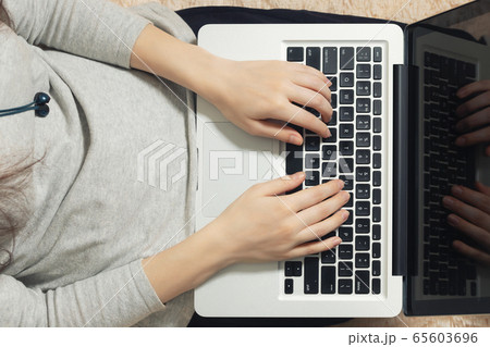 Girl working on a laptop at home on the couch. Freelance and Remote Quarantine Concept, top view 65603696