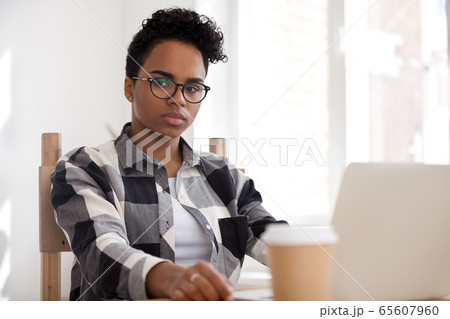 Pensive thoughtful african-american woman thinking of problem solution at work Pensive thoughtful african-american woman thinking of problem solution at work 65607960