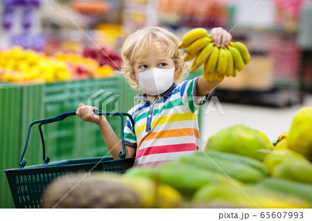Child in supermarket. Kid grocery shopping. 65607993