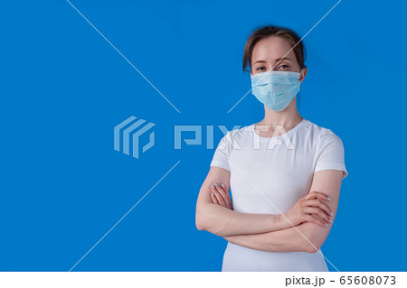 Woman wearing medical face mask, looking at camera - quarantine concept 65608073