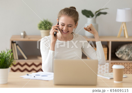 Happy girl excited hearing good news talking on phone 65609115