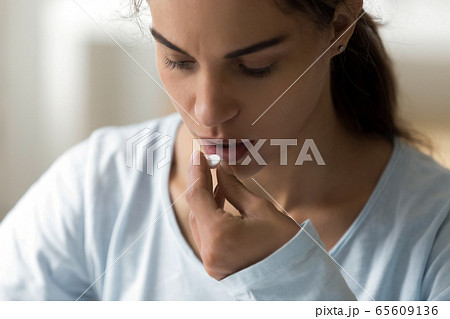 Millennial lady taking vitamins medicine, antidepressant, painkiller. Millennial lady taking vitamins medicine, antidepressant, painkiller. 65609136