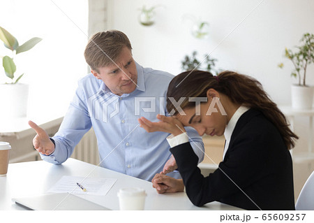 Mad team leader blaming incompetent intern or trainee. Mad team leader blaming incompetent intern or trainee. 65609257