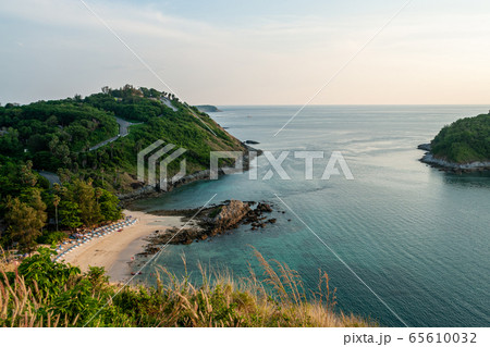 View from the mountain to the morning beach with tourists resting and swimming, surrounded by green islands near the sea water during sunrise and blue clear sky without clouds. Thailand. Active life. 65610032