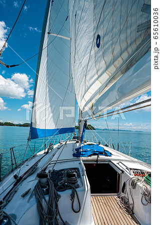 Ship yachts with white sails in the open sea with islands in the background. View from the sailing boat deck who is ready go on a trip by andaman water. Vacation, travel, cruise. Luxury boats. 65610036