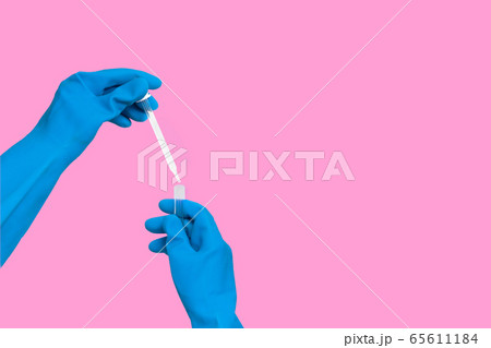 Hand in glove with dropper into test tube 65611184