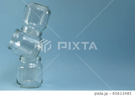 Vertical row of crooked glass jars on top of each Vertical row of crooked glass jars on top of each 65613485