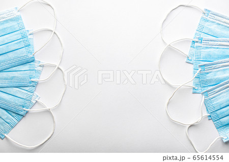 Several medical blue disposable protective masks one on top of other in form of fan on white background. surgical dressing closes mouth and nose. Healthcare, medicine, covid-19, epidemic concept. Several medical blue disposable protective masks one on top of other in form of fan on white background. surgical dressing closes mouth and nose. Healthcare, medicine, covid-19, epidemic concept. 65614554