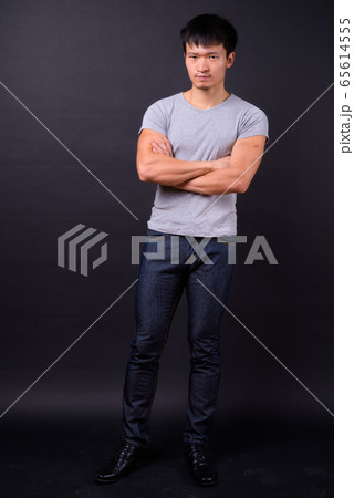 Portrait of young Asian man with arms crossed Portrait of young Asian man with arms crossed 65614555