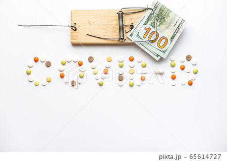 covid-19 inscription with pills and capsules and hundred dollar bill caught in a wooden mousetrap in layout on a white background copy space. Coronavirus, medicine and health, safety concept. covid-19 inscription with pills and capsules and hundred dollar bill caught in a wooden mousetrap in layout on a white background copy space. Coronavirus, medicine and health, safety concept. 65614727