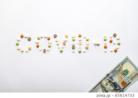 covid-19 inscription with pills and capsules and 100 dollar bill in layout on a white background copy space. Coronavirus, medicine and health, safety concept. covid-19 inscription with pills and capsules and 100 dollar bill in layout on a white background copy space. Coronavirus, medicine and health, safety concept. 65614733