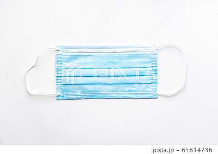 Medical blue disposable protective mask on a white background copy space. A surgical dressing closes the mouth and nose. Healthcare, medicine, covid-19, epidemic concept. Medical blue disposable protective mask on a white background copy space. A surgical dressing closes the mouth and nose. Healthcare, medicine, covid-19, epidemic concept. 65614736