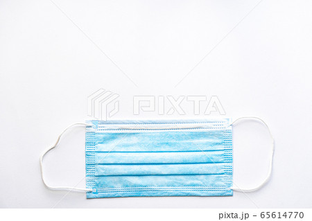 Medical blue disposable protective mask on a white background copy space. A surgical dressing closes the mouth and nose. Healthcare, medicine, covid-19, epidemic concept. Medical blue disposable protective mask on a white background copy space. A surgical dressing closes the mouth and nose. Healthcare, medicine, covid-19, epidemic concept. 65614770