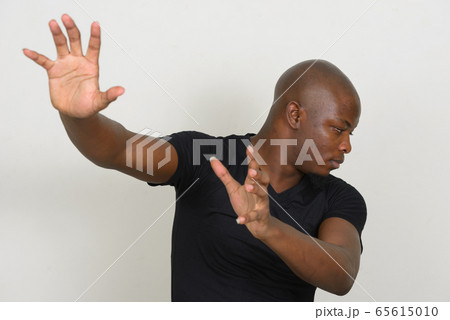 Stressed young bald African man looking scared Stressed young bald African man looking scared 65615010