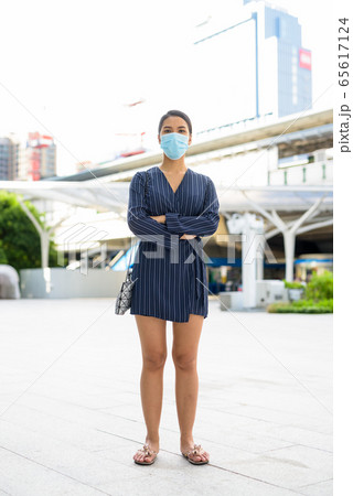 Full body shot of young Asian businesswoman wearing mask for protection from corona virus outbreak 65617124