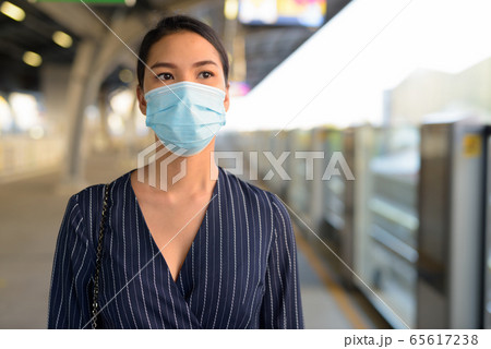 Young Asian businesswoman waiting with mask for protection from corona virus outbreak at the Young Asian businesswoman waiting with mask for protection from corona virus outbreak at the 65617238