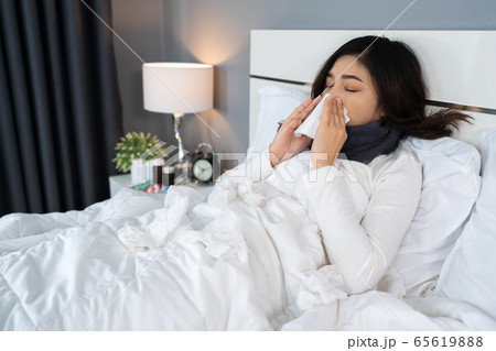 sick woman feeling cold and sneezing in bed sick woman feeling cold and sneezing in bed 65619888