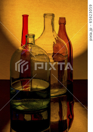 Still life with colored glassware on a yellow background Still life with colored glassware on a yellow background 65623059