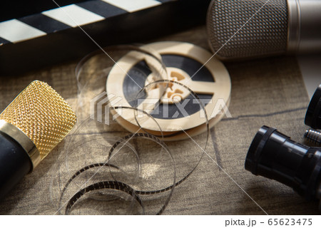 Film reel, movie clapperboard, two microphones and 65623475