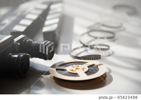 Unwound narrow retro film on a light reel against 65623498