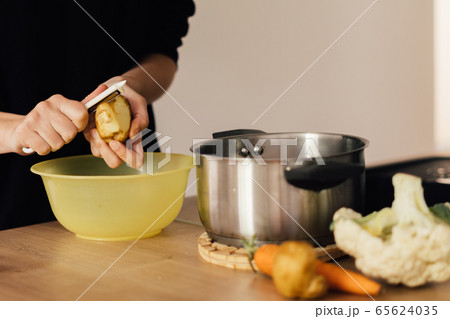 Millennial young woman cooking food, peeling potato at home kitchen. Circular economy, real food 65624035
