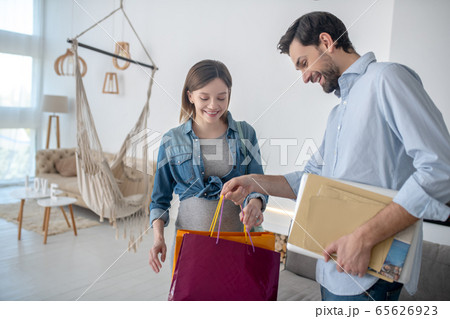 Dark-haired man holding shopping bags and smiling 65626923