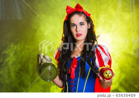 Danger, nuclear and radiation measurement - Girl holds apple with radiation hazard symbol. 65630489