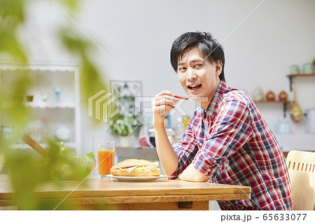 食卓を囲む若い男性 65633077