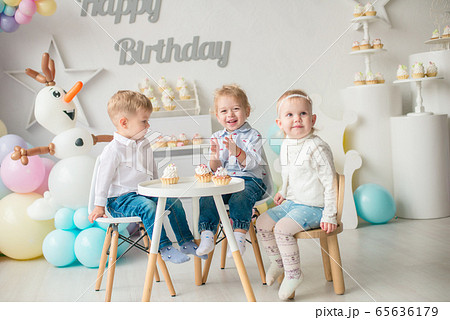 Cute little boys and girl at a table with birthday cakes at a children's party with balloons. Children's party. Balloons 65636179
