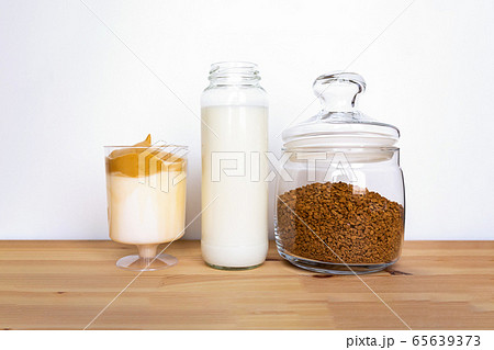 Dalgona coffee ingredients in jars on table. Dalgona coffee ingredients in jars on table. 65639373