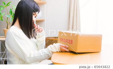 郵便物を見て悩む女性　疑問、悩み、トラブル、詐欺　16:9 65643822