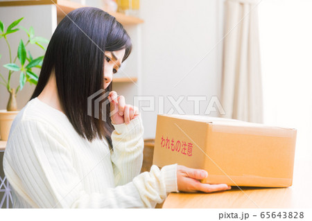 郵便物を見て悩む女性　疑問、悩み、トラブル、詐欺　 65643828
