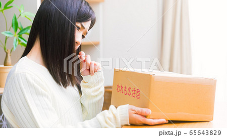 郵便物を見て悩む女性　疑問、悩み、トラブル、詐欺　16:9 65643829