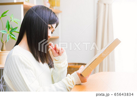 郵便物を見て悩む女性 疑問、悩み、トラブル、詐欺 郵便物を見て悩む女性 疑問、悩み、トラブル、詐欺 65643834