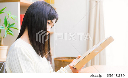 郵便物を見て悩む女性　疑問、悩み、トラブル、詐欺　16:9 65643839