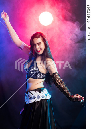Young woman dancing in Tribal Fusion style. Belly dance on the stage. 65647043